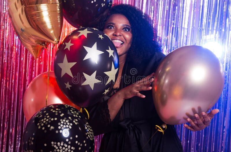 Schöne schwarze Frau, die einen Parteilebensstil genießt. Geburtstagsfeier den Club und Feiertagskonzept.