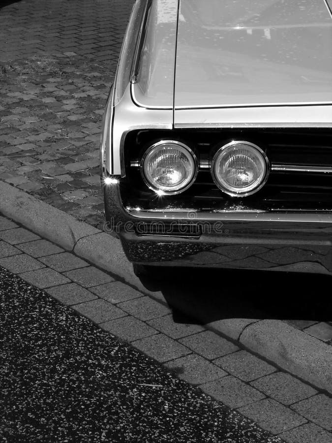 Schöne Schwarzweißaufnahme des Grills und der Scheinwerfer eines alten Retro- Autos stockfotografie