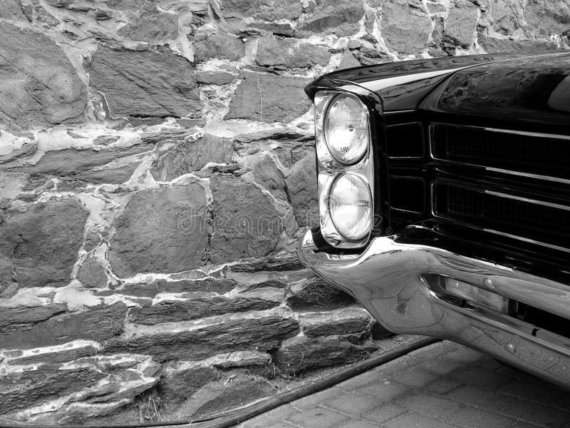 Schöne Schwarzweißaufnahme des Grills und der Scheinwerfer eines alten Retro- Autos stockfotografie