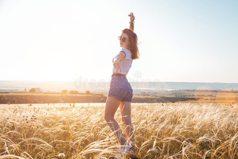 Schöne sexy junge Frau, die in SonnenunterSonnenunterSonnenunterSonnenuntergangszeit auf wunderschöne Landschaft lächelnd lächelt lizenzfreies stockbild Schöne sexy junge Frau, die in SonnenunterSonnenunterSonnenunterSonnenuntergangszeit auf wunderschöne Landschaft lächelnd lächelt lizenzfreies stockbild