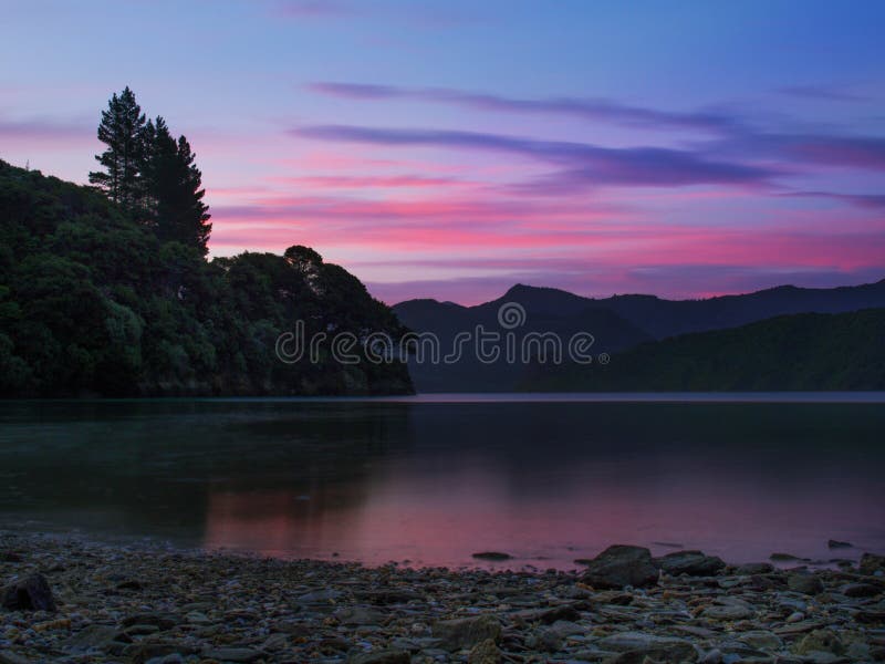 Schöne Sonnenuntergangnachglut, die an Kenepuru-Ton, Neuseeland sich reflektiert stockfotografie Schöne Sonnenuntergangnachglut, die an Kenepuru-Ton, Neuseeland sich reflektiert stockfotografie
