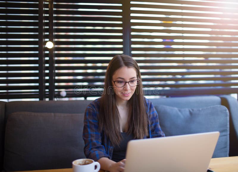 Schöne Studentin, die Informationen im Internet über Netzbuch oder Notizbuch sucht lizenzfreies stockbild