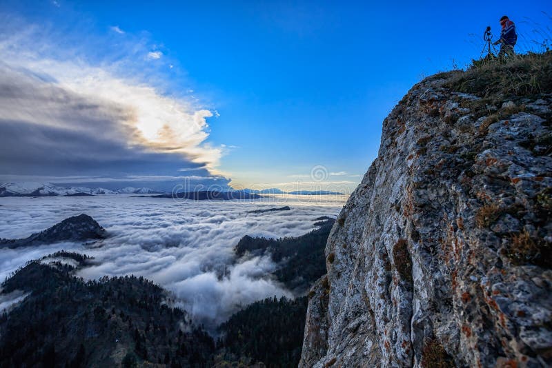 Schöne szenische Herbstberglandschaft bei Sonnenuntergang mit tiefen Wolken und einem Mann, der auf dem Felsen steht und Fotos mi stockbilder Schöne szenische Herbstberglandschaft bei Sonnenuntergang mit tiefen Wolken und einem Mann, der auf dem Felsen steht und Fotos mi stockbilder