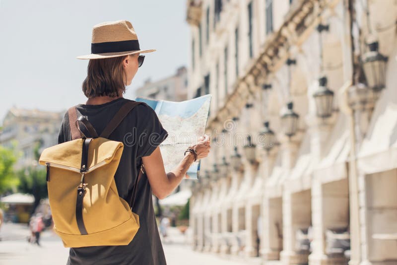 Schöne touristische Frau steht mit Karte in Kerkyra Altstadt während des Urlaubs fröhliches Studentenmädchen, das im Sommer ins Au stockbilder