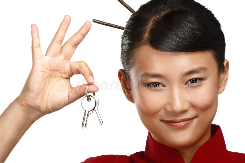 Schöne traditionelle asiatische chinesische Frau, die flache Schlüssel zeigt stockfotografie Schöne traditionelle asiatische chinesische Frau, die flache Schlüssel zeigt stockfotografie