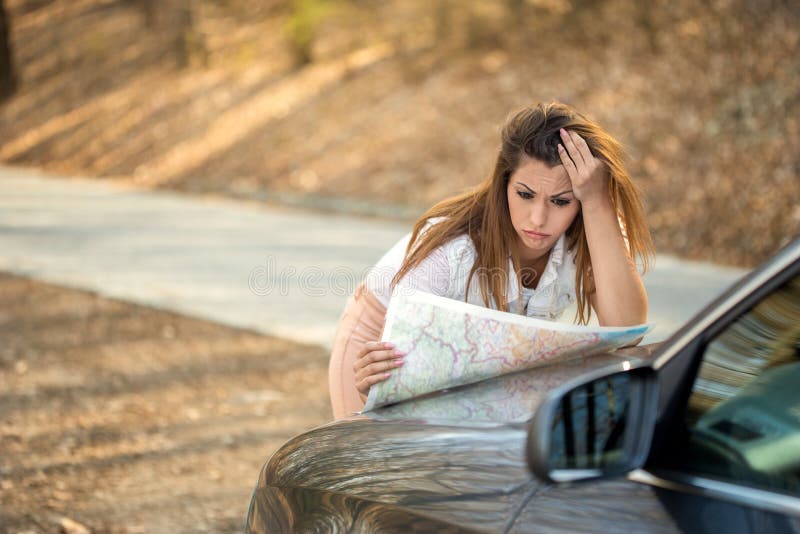 Schöne verlorene Frau, die eine Karte auf der Seite der Straße betrachtet stockfotografie Schöne verlorene Frau, die eine Karte auf der Seite der Straße betrachtet stockfotografie