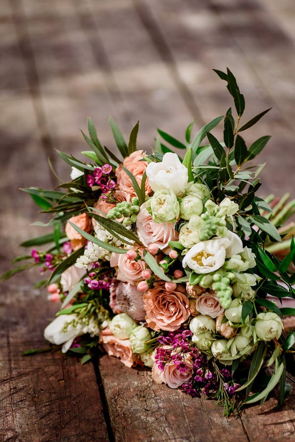 Schöner Blumenstrauß der Braut auf einem hölzernen Hintergrund lizenzfreies stockbild Schöner Blumenstrauß der Braut auf einem hölzernen Hintergrund lizenzfreies stockbild