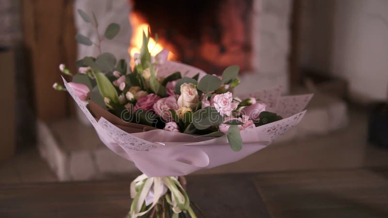 Schöner Blumenstrauß von Pastellfarbblumen in den rosa dekorativen Papierständen auf den Stämmen auf einer grauen Tabelle nach de stock footage Schöner Blumenstrauß von Pastellfarbblumen in den rosa dekorativen Papierständen auf den Stämmen auf einer grauen Tabelle nach de stock footage