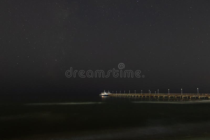 Schöner Hintergrund mit dem Bild der Tabelle Kleiner Vergnügungsdampfer festgemacht zu einem Pier nahe der Seeküste lizenzfreies stockfoto Schöner Hintergrund mit dem Bild der Tabelle Kleiner Vergnügungsdampfer festgemacht zu einem Pier nahe der Seeküste lizenzfreies stockfoto