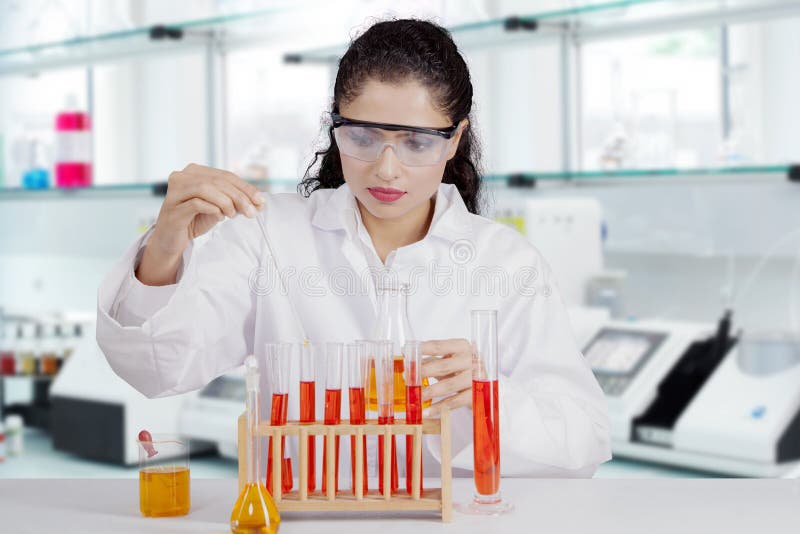 Schöner indischer Wissenschaftler, der im Labor arbeitet lizenzfreie stockfotografie Schöner indischer Wissenschaftler, der im Labor arbeitet lizenzfreie stockfotografie