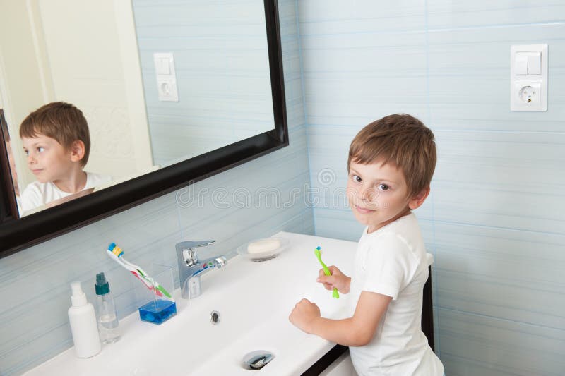 Beautiful little kid with toothbrush in hand in bright bathroom. Beautiful little kid with toothbrush in hand in bright bathroom