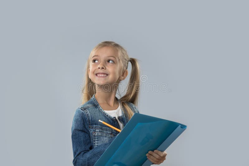 Schöner kleines Mädchen-Griff-Bleistift, der glücklichen lächelnden Blick schreibt, um den Raum zu kopieren lokalisiert lizenzfreie stockfotografie Schöner kleines Mädchen-Griff-Bleistift, der glücklichen lächelnden Blick schreibt, um den Raum zu kopieren lokalisiert lizenzfreie stockfotografie