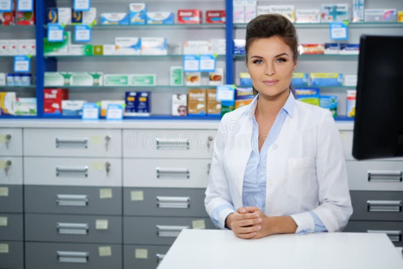 Schöner lächelnder Apotheker der jungen Frau, der seins Arbeit in der Apotheke tut lizenzfreies stockfoto Schöner lächelnder Apotheker der jungen Frau, der seins Arbeit in der Apotheke tut lizenzfreies stockfoto