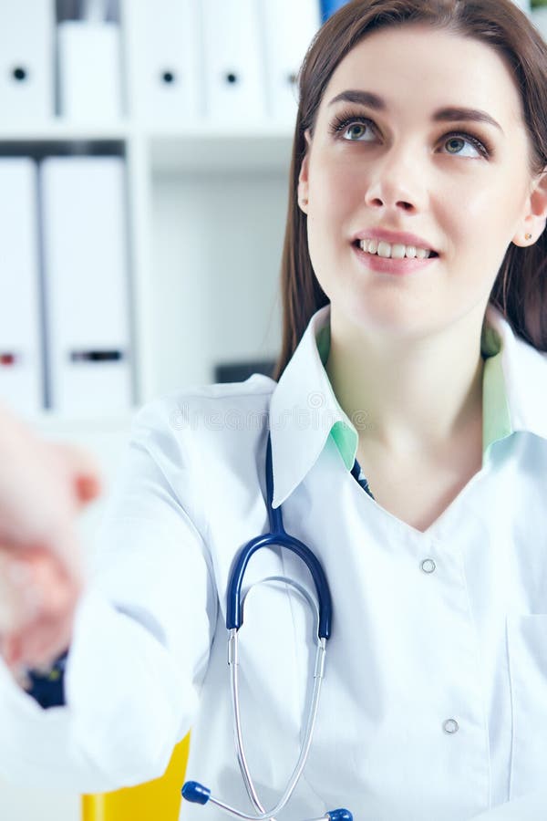 Schöner lächelnder weiblicher Medizindoktor, der Hände mit Patienten rüttelt Partnerschaft, Vertrauen und Konzept der medizinisch stockfotografie Schöner lächelnder weiblicher Medizindoktor, der Hände mit Patienten rüttelt Partnerschaft, Vertrauen und Konzept der medizinisch stockfotografie