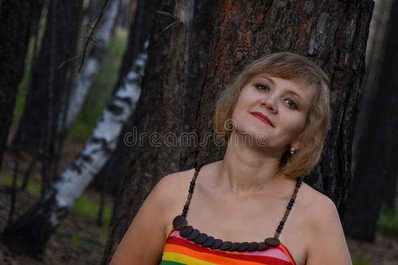 Schöner Sitz der jungen Frau unter dem Baum Schönes Porträt der jungen Frau draußen im Wald stockfotos Schöner Sitz der jungen Frau unter dem Baum Schönes Porträt der jungen Frau draußen im Wald stockfotos