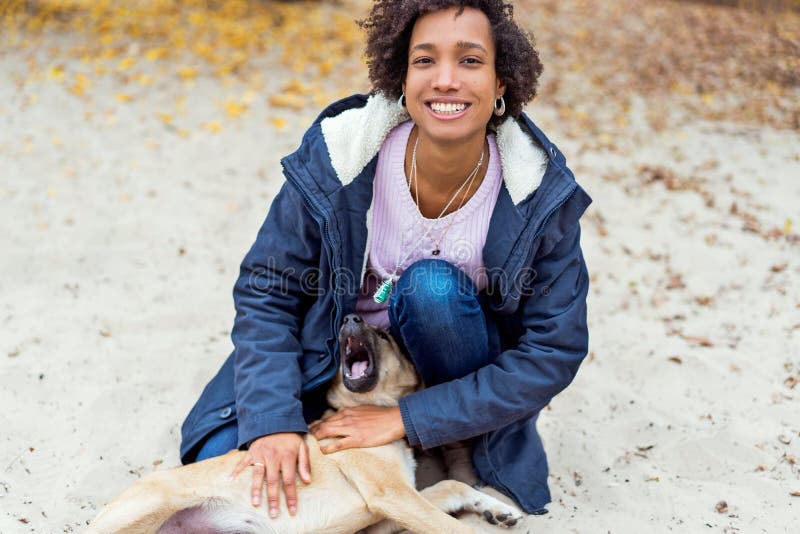 Schönes afrikanisches Mädchen im Herbstpark auf der Natur spielt mit Hund lizenzfreie stockfotos Schönes afrikanisches Mädchen im Herbstpark auf der Natur spielt mit Hund lizenzfreie stockfotos