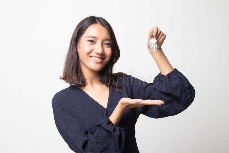 Schönes asiatisches Mädchen, das Hauptwohnsitzschlüssel zeigt lizenzfreies stockbild