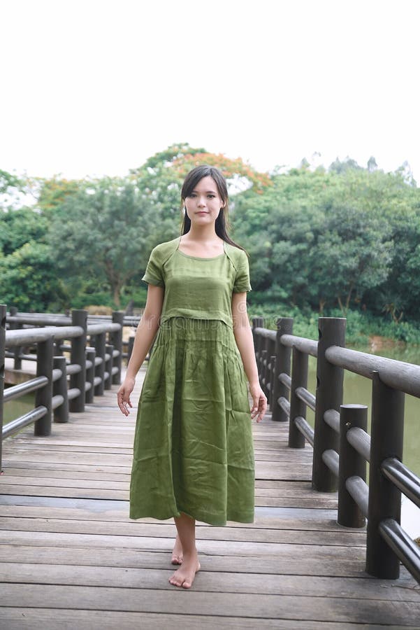 Schönes asiatisches Mädchen kleidete im traditionellen Elementkleid an, das sich zeigt lizenzfreie stockfotografie Schönes asiatisches Mädchen kleidete im traditionellen Elementkleid an, das sich zeigt lizenzfreie stockfotografie
