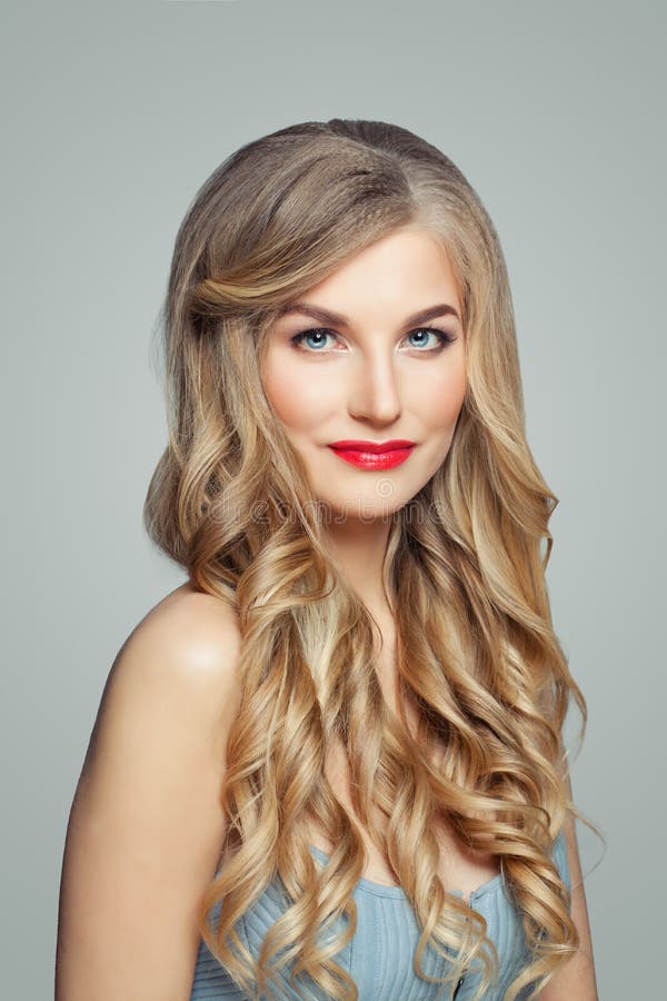 Beautiful blonde woman portrait. Elegant female model with long healthy curly hair and red lips makeup. Beautiful blonde woman portrait. Elegant female model with long healthy curly hair and red lips makeup.