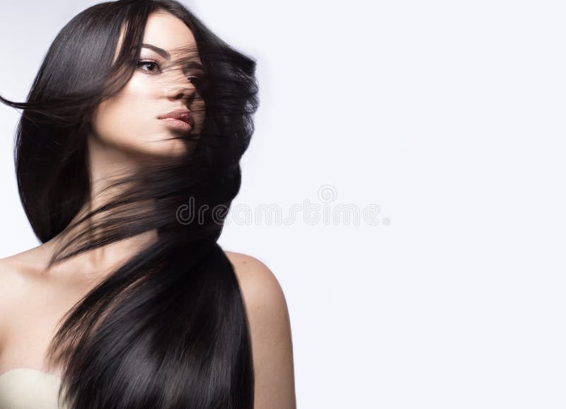 Schönes Brunettemädchen in der Bewegung mit einem tadellos glatten Haar und klassisches Make-up Schönes lächelndes Mädchen stockfotografie