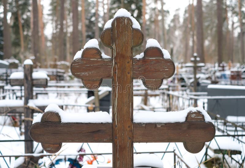 Schönes hölzernes Kreuz der traditionellen Form und der künstlichen Blumen auf dem Grab des orthodoxen Kirchhofs im Winter stockbilder Schönes hölzernes Kreuz der traditionellen Form und der künstlichen Blumen auf dem Grab des orthodoxen Kirchhofs im Winter stockbilder