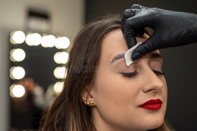 beautiful young girl in a salon where she is getting foam on her eyebrows to degrease them. the concept of eyebrow lamination. beautiful young girl in a salon where she is getting foam on her eyebrows to degrease them. the concept of eyebrow lamination