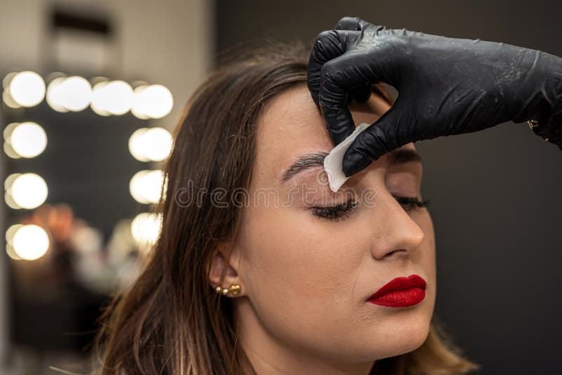 beautiful young girl in a salon where she is getting foam on her eyebrows to degrease them. the concept of eyebrow lamination. beautiful young girl in a salon where she is getting foam on her eyebrows to degrease them. the concept of eyebrow lamination