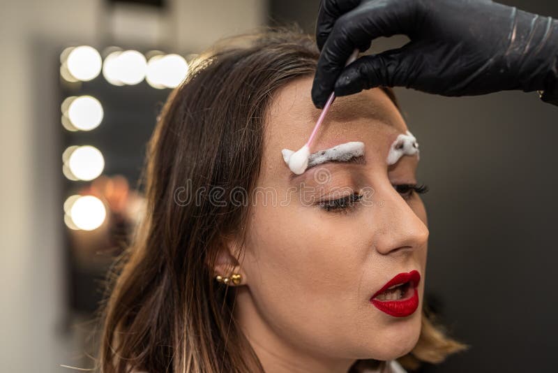 beautiful young girl in a salon where she is getting foam on her eyebrows to degrease them. the concept of eyebrow lamination. beautiful young girl in a salon where she is getting foam on her eyebrows to degrease them. the concept of eyebrow lamination