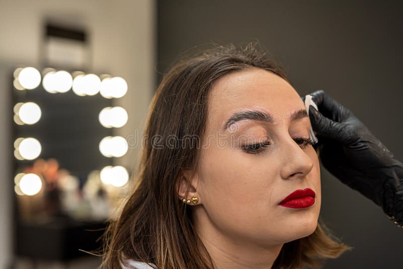 beautiful young girl in a salon where she is getting foam on her eyebrows to degrease them. the concept of eyebrow lamination. beautiful young girl in a salon where she is getting foam on her eyebrows to degrease them. the concept of eyebrow lamination