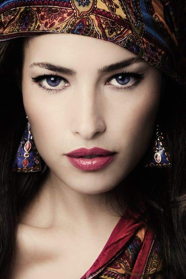 Schönes, junges Portrait im orientalischen Stil mit bunten Ohrringen und Schal lizenzfreies stockbild Schönes, junges Portrait im orientalischen Stil mit bunten Ohrringen und Schal lizenzfreies stockbild