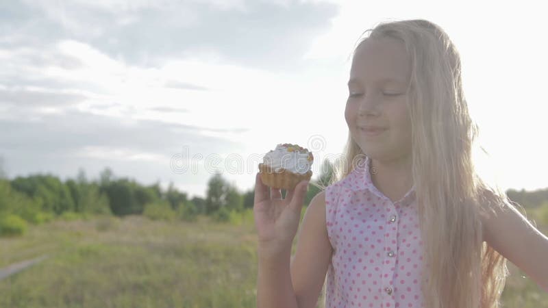 Schönes, kleines Mädchen, das Schokoladenkuchen isst