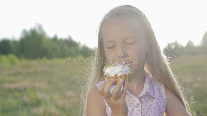 Schönes, kleines Mädchen, das Schokoladenkuchen isst