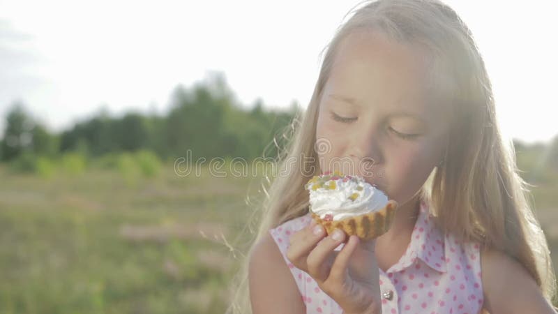 Schönes, kleines Mädchen, das Schokoladenkuchen isst