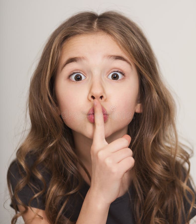 Schönes kleines Mädchen mit dem Finger auf Lippen f lizenzfreie stockfotos Schönes kleines Mädchen mit dem Finger auf Lippen f lizenzfreie stockfotos