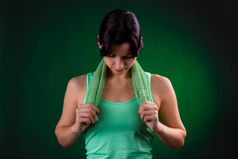 Schönes Lächeln athletisch, Eignungsfrauenstellung, werfend mit einem Tuch auf einem grauen Hintergrund mit einer grünen Hintergr stockfotos Schönes Lächeln athletisch, Eignungsfrauenstellung, werfend mit einem Tuch auf einem grauen Hintergrund mit einer grünen Hintergr stockfotos