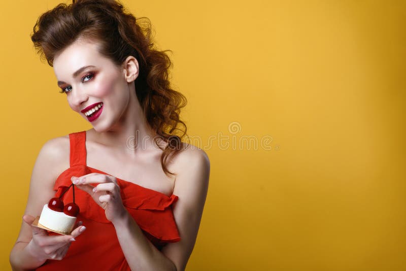 Schönes Modell mit kreativer Frisur und bunte bilden das Halten des geschmackvollen Gebäcks verziert mit Kirschen auf die Obersei stockbild Schönes Modell mit kreativer Frisur und bunte bilden das Halten des geschmackvollen Gebäcks verziert mit Kirschen auf die Obersei stockbild