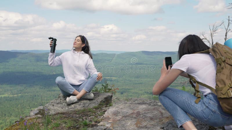 Schönes Mädchen, das auf einen Berg für einen Freund darstellt.