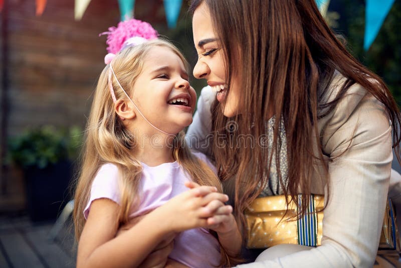 Schönes Mädchen, das in einer Umarmung einer jungen Frauen Erwachsenen Geburtstagsfeier kichert. positive Gefühle der Liebe der en lizenzfreies stockbild