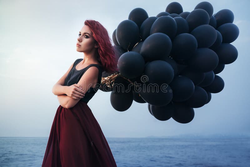 Schönes Mädchen, das mit schwarzen Ballonen geht lizenzfreies stockbild Schönes Mädchen, das mit schwarzen Ballonen geht lizenzfreies stockbild