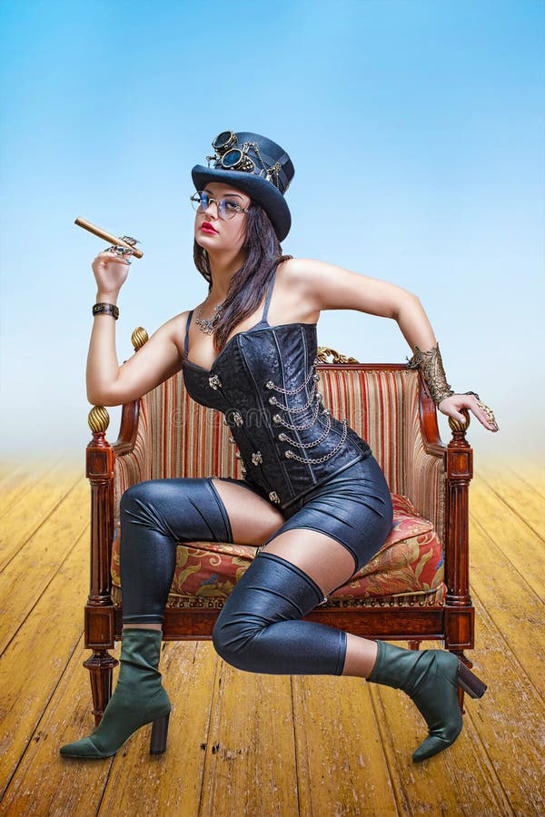 Schönes Mädchen in einem Korsett, in einem Fedorahut und steampunk in schweißenden Gläsern, mit einer Zigarre in ihrer Hand lizenzfreies stockfoto Schönes Mädchen in einem Korsett, in einem Fedorahut und steampunk in schweißenden Gläsern, mit einer Zigarre in ihrer Hand lizenzfreies stockfoto