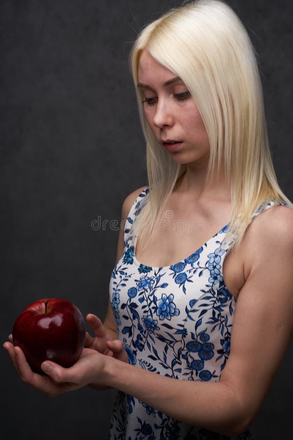 Schönes Mädchen in einer modischen Kleidung mit Apfel lizenzfreies stockbild Schönes Mädchen in einer modischen Kleidung mit Apfel lizenzfreies stockbild