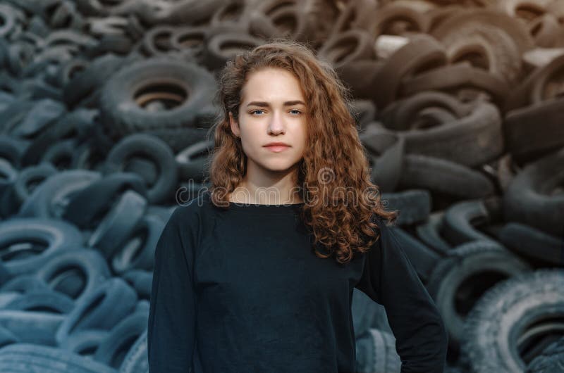 Schönes Mädchen, geschmeidig Haare, Portrait auf dem Hintergrund einer Müllhalde alter Autoreifen Kameraaufnahme stockfoto Schönes Mädchen, geschmeidig Haare, Portrait auf dem Hintergrund einer Müllhalde alter Autoreifen Kameraaufnahme stockfoto