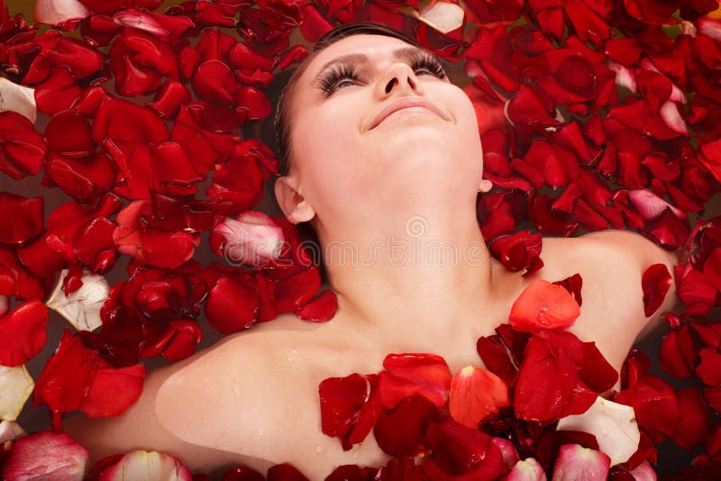 Schönes Mädchen im Jacuzzi mit dem rosafarbenen Blumenblatt. lizenzfreies stockfoto Schönes Mädchen im Jacuzzi mit dem rosafarbenen Blumenblatt. lizenzfreies stockfoto