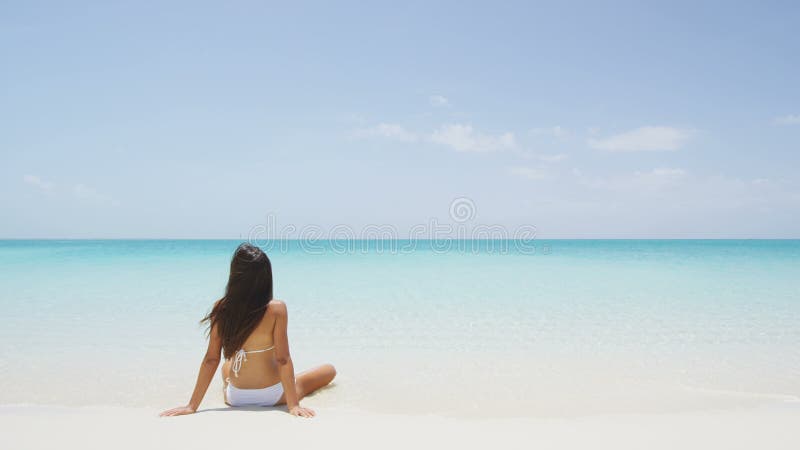 Schönes Mädchen im weißen Badeanzugbikini am Strand auf Fernluxusferien