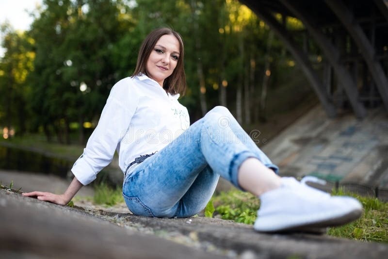 Schönes Mädchen in Jeans und eine weiße Bluse. stockfotografie