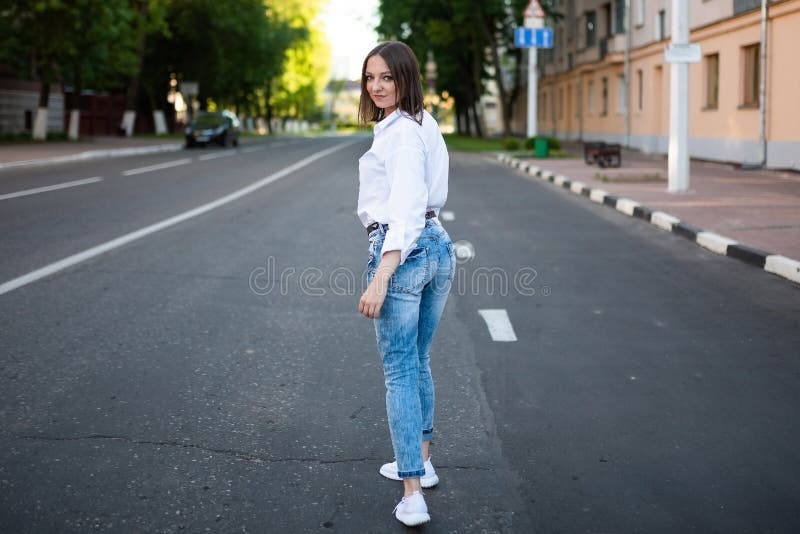 Schönes Mädchen in Jeans und eine weiße Bluse. stockbilder