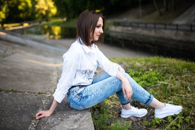 Schönes Mädchen in Jeans und eine weiße Bluse. stockbild