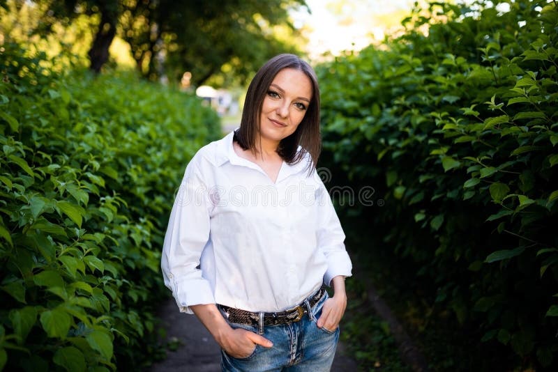 Schönes Mädchen in Jeans und eine weiße Bluse. lizenzfreie stockfotos