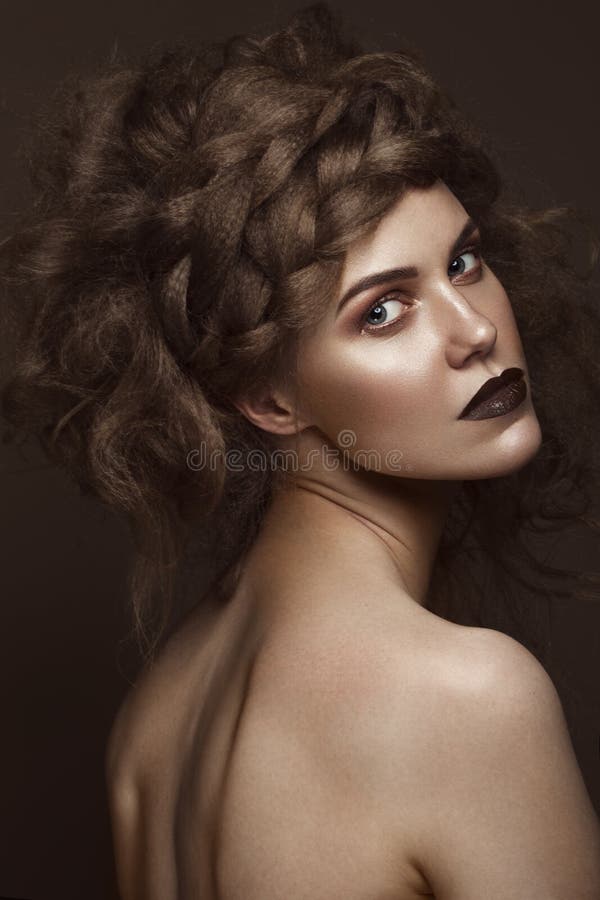 Schönes Mädchen mit kreativer Frisurkunst, perfekter Haut und Dunkelheitsmake-up Die Schönheit des Gesichtes stockfoto