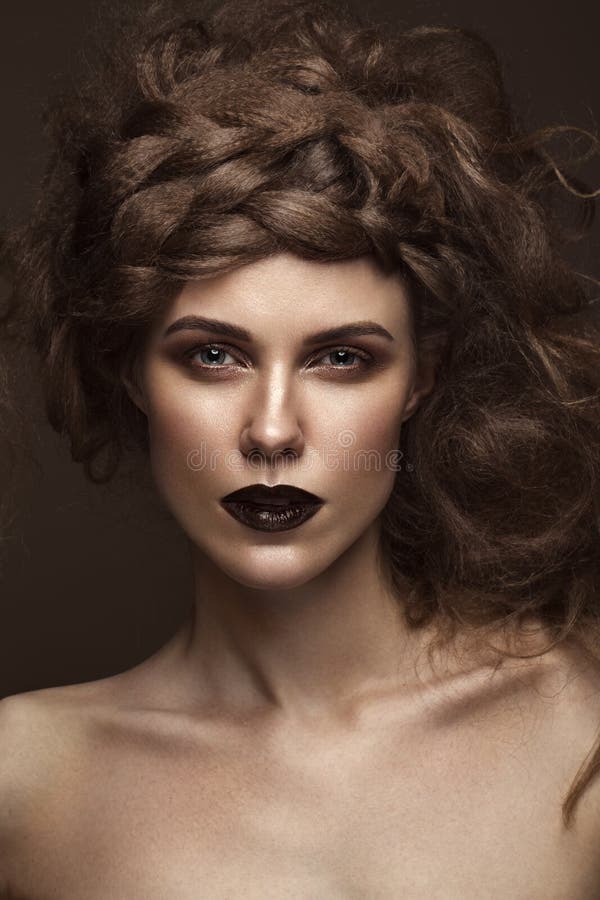 Schönes Mädchen mit kreativer Frisurkunst, perfekter Haut und Dunkelheitsmake-up Die Schönheit des Gesichtes lizenzfreies stockbild